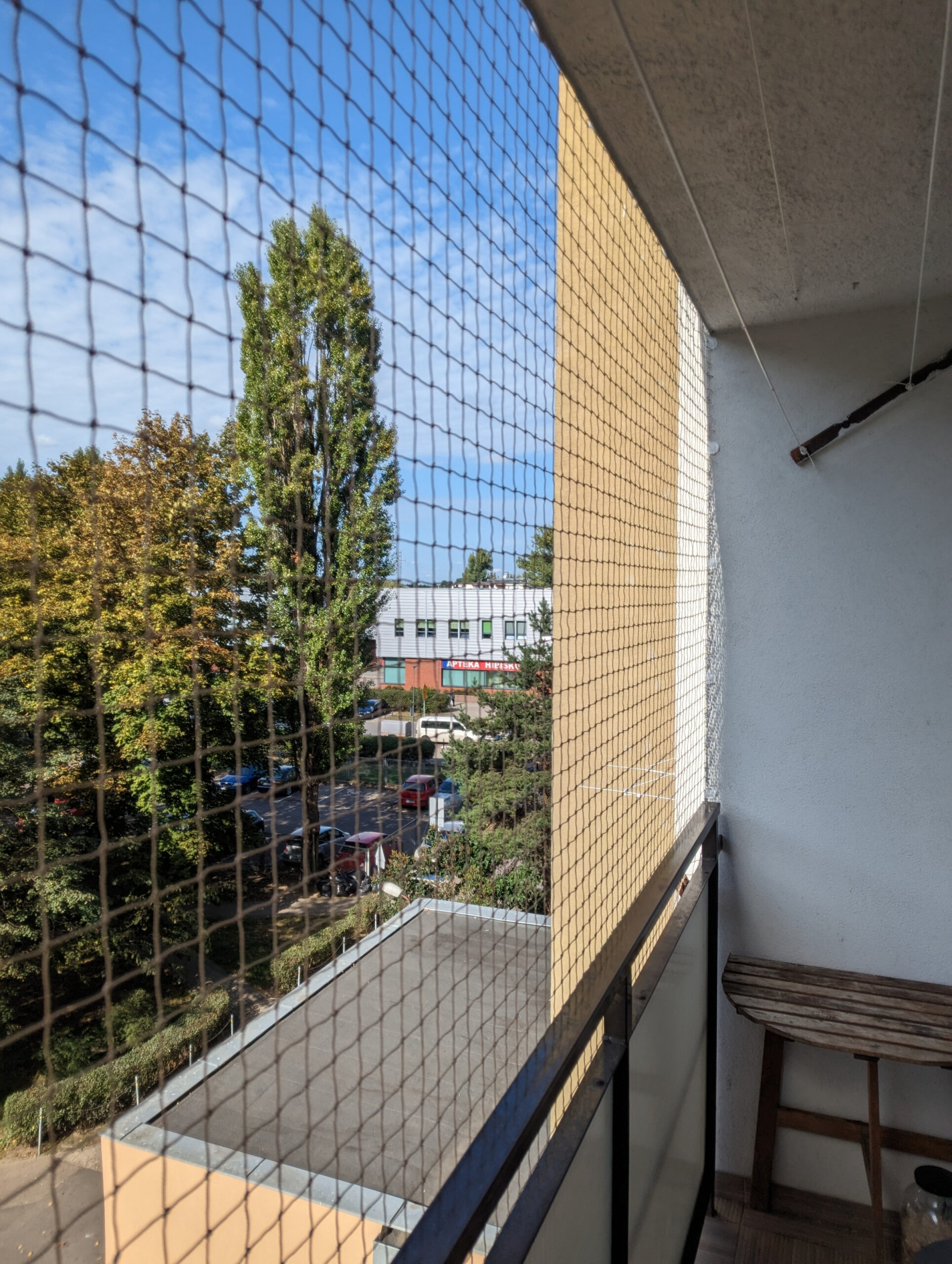 Gęsta siatka na gołębie zamontowana na balustradzie balkonowej, chroniąca elewację przed ptakami i zabrudzeniami.