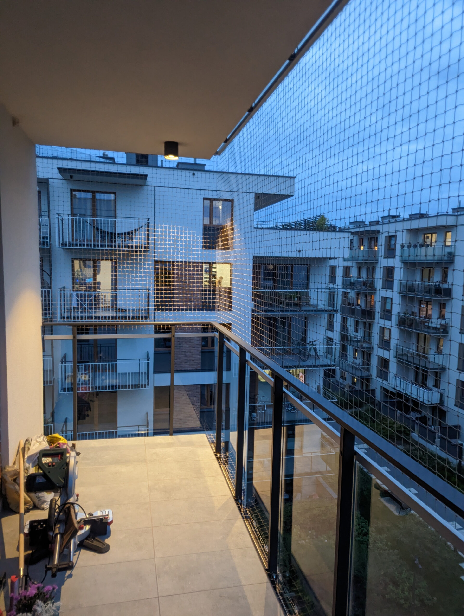 Nowoczesna aranżacja tarasu z niemal niewidoczną siatką zabezpieczającą, która nie ogranicza widoku i pasuje do elewacji.